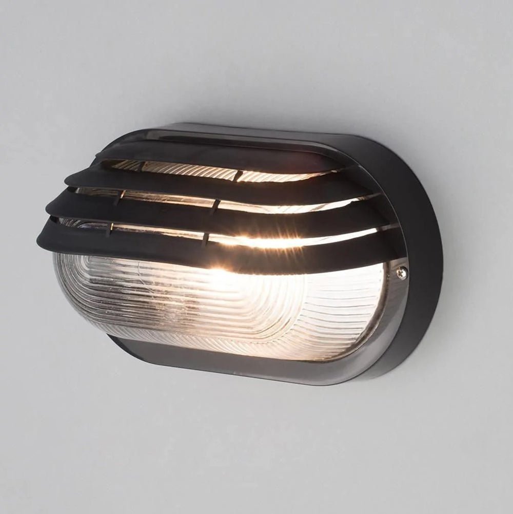 PUCK | Oval Bulkhead Outdoor Glass Wall Light Fitting | E27 | IP44 | Black Caged - LightHub Direct