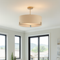 Modern living room with beige sofa, chair, and coffee table under a pendant light.