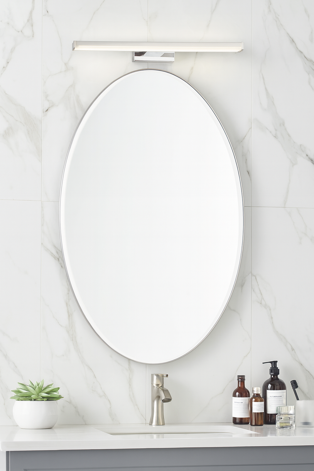 Bathroom vanity with oval mirror, sink, and toiletries on a marble wall background