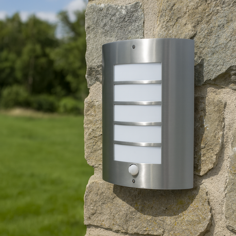 Outdoor wall light fixture on a stone wall with grass and trees in the background
